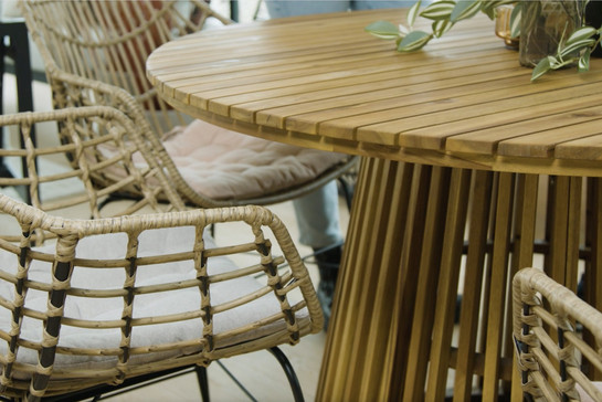 Runder Gartentisch aus Holz und geflochtene Stühle