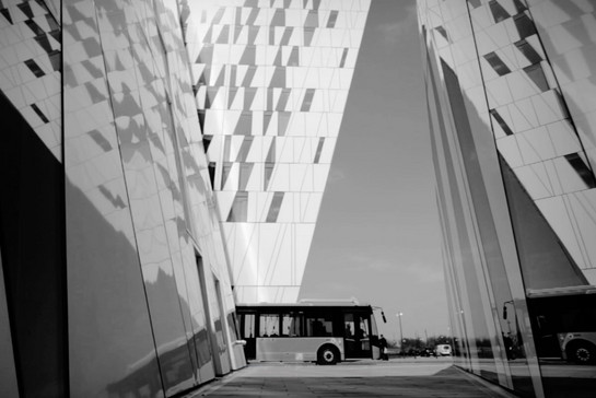 Ein Bus fährt zwischen modernen Gebäuden