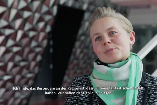 Eine blonde Frau mit grünem Schal im Interview