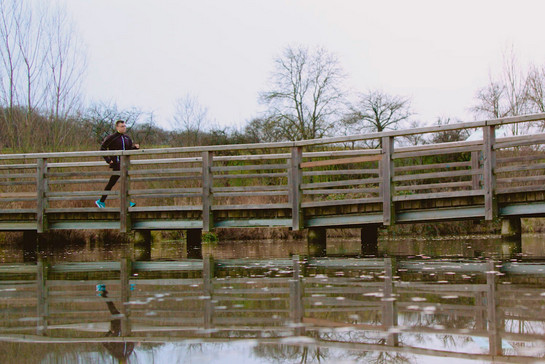 Ein Mann joggt über eine Brücke