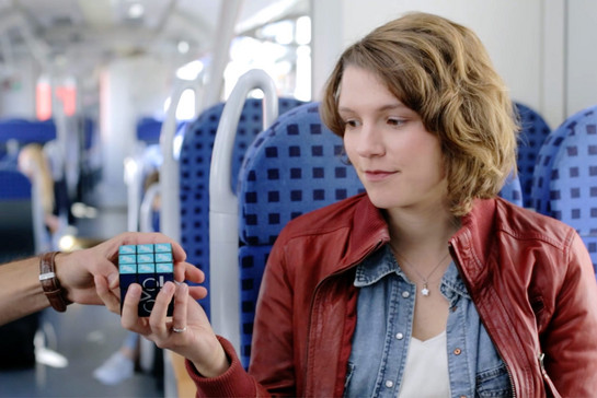 Eine Frau kriegt einen Cube in die Hand gedrückt