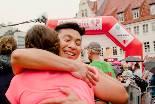 Ein Marathon Läufer umarmt eine andere Marathon Läuferin