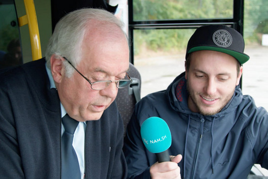 Ein Mann interviewt den Busfahrer Helmut