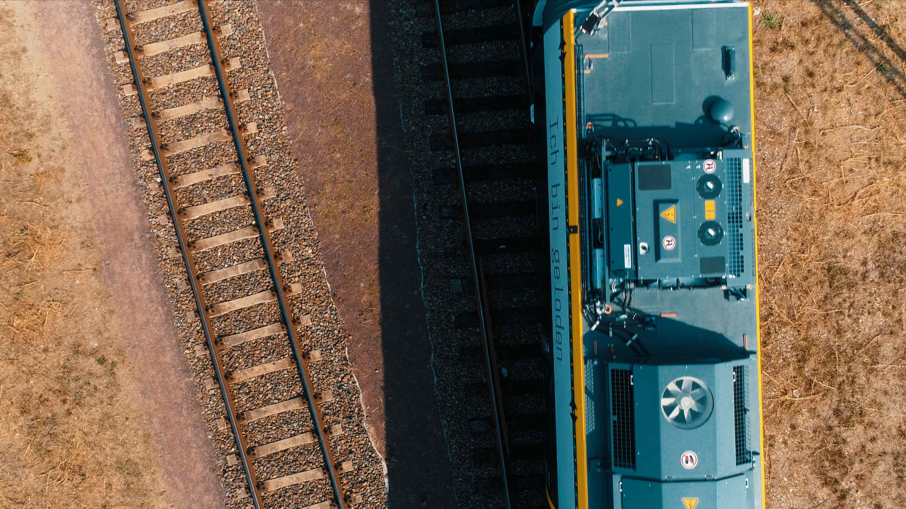 Luftaufnahme, ein blauer Zug und Gleisen. 