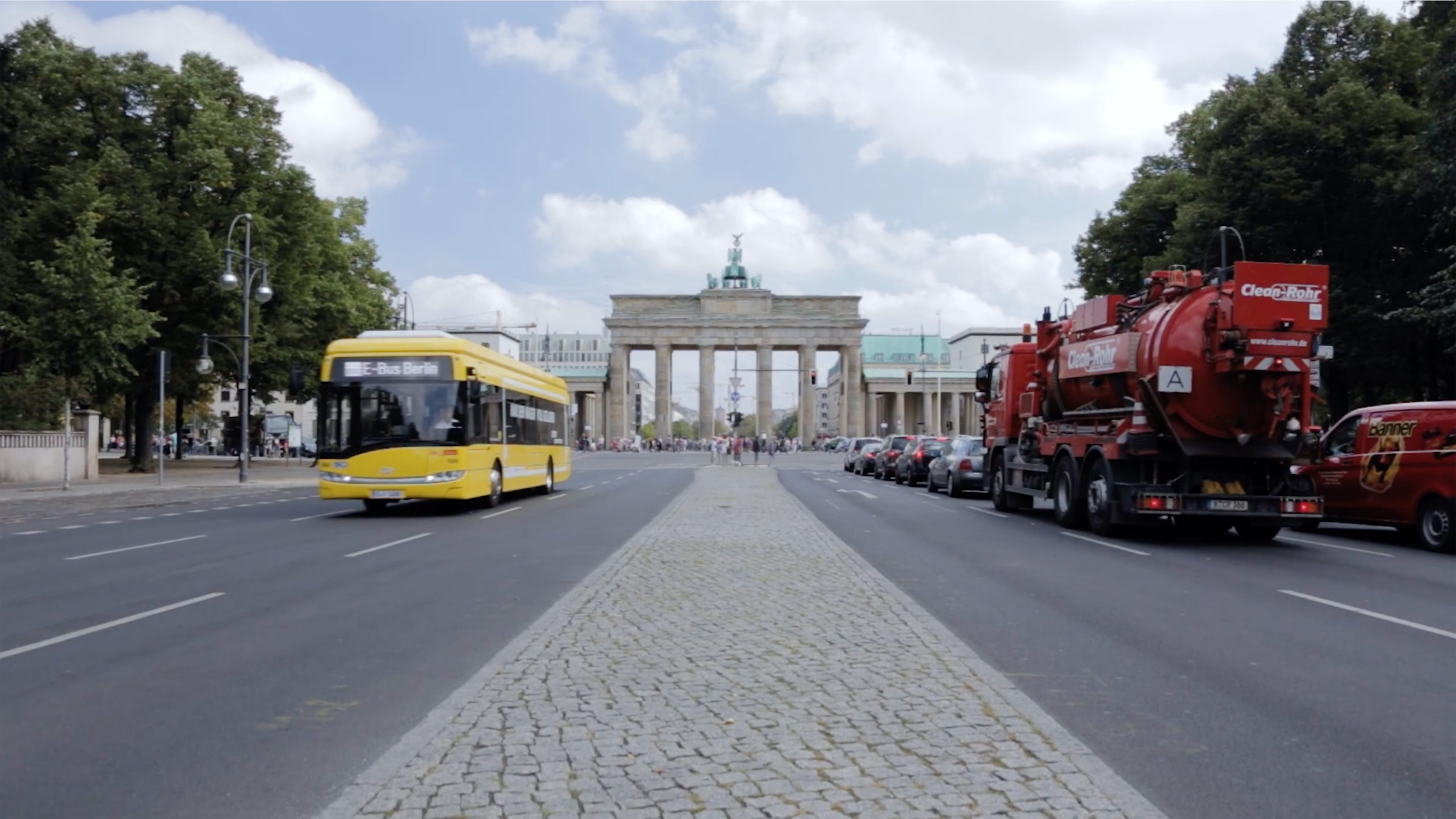 Ein Stadtbus in der Innenstadt von Berlin, im Hintergrund das Brandenburger Tor. 