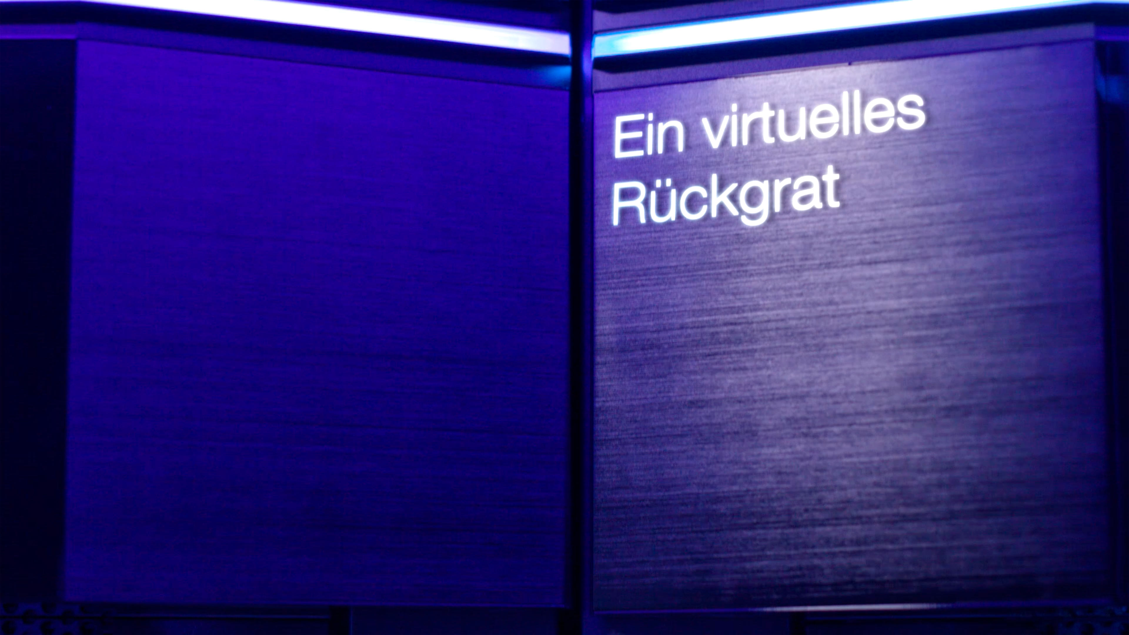 Weiße Schrift "Ein virtuelles Rückgrad" auf einer blauen Tafel