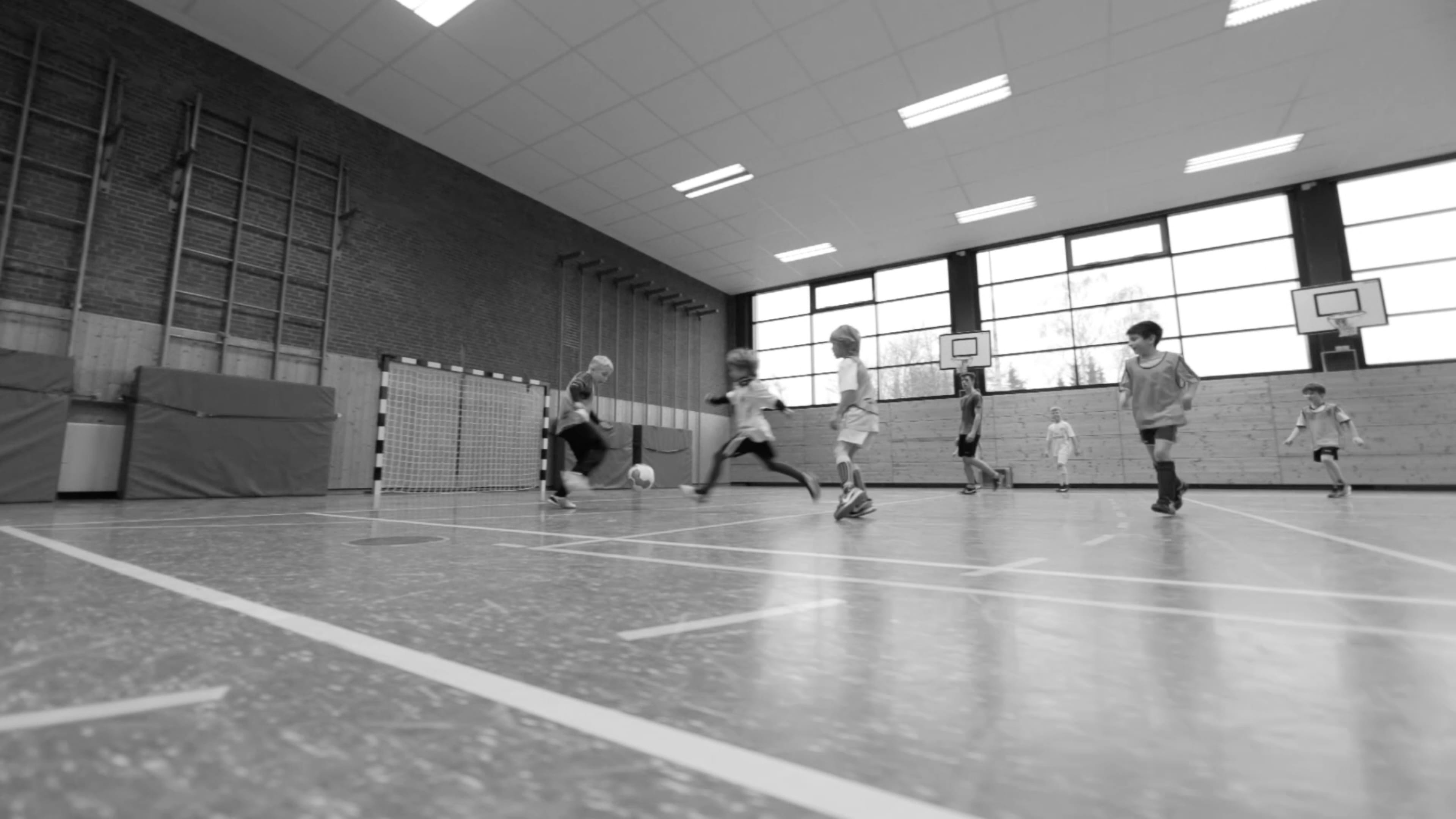 Kinder spielen Fußball in der Halle