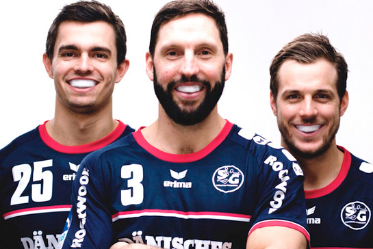 Drei Handballspieler tragen einen Mundschutz