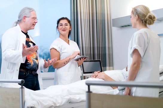 bb_outtakes_teaser_04.jpg Medizinisches Personal steht um das Bett eines Patienten