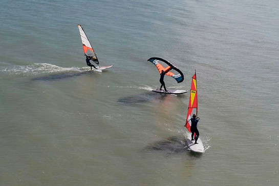 bb_talb_teaser_02.jpg Drei Windsurfer stehen auf dem Wasser