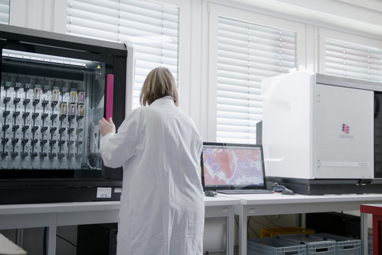 Eine Frau steht vor einer Maschine im Labor