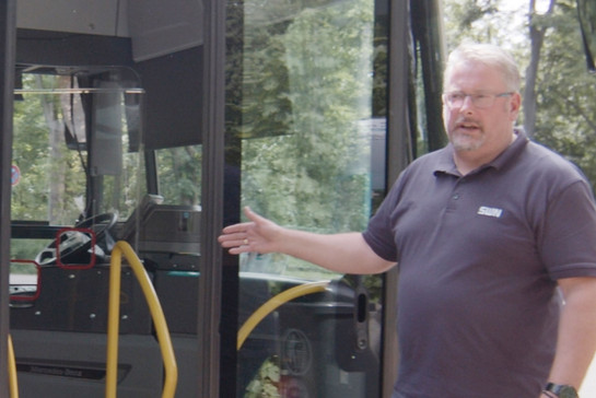 Ein Busfahrer zeigt seinen Bus