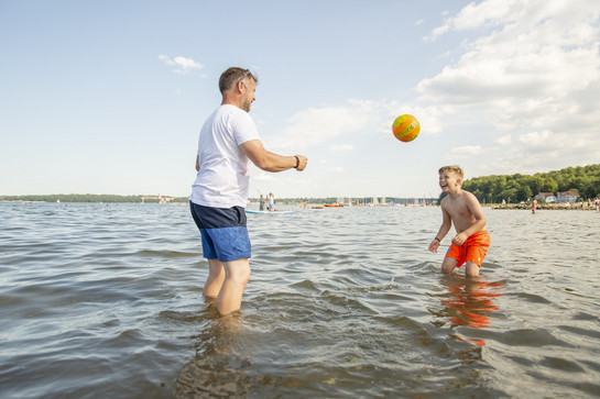 bb_flfj-fotoshooting_teaser_06.jpg Ein Vater und sein Sohn spielen Ball im Wasser