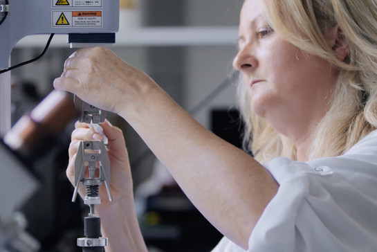 Eine blonde Frau benutzt eine Maschine für Kontaktlinse