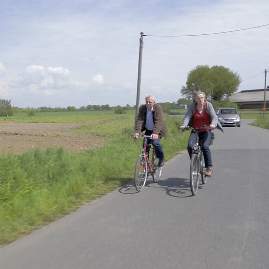 Zwei Fahrradfahrer fahren auf einer Landstraße
