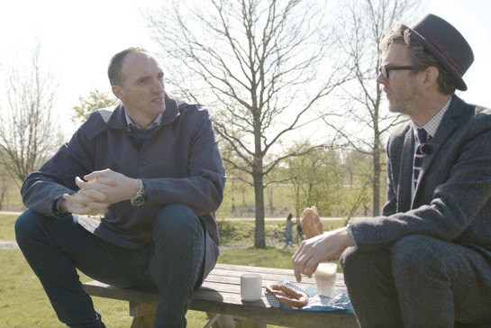 Jim Lacy und Holger Glandorf unterhalten sich auf einer Parkbank