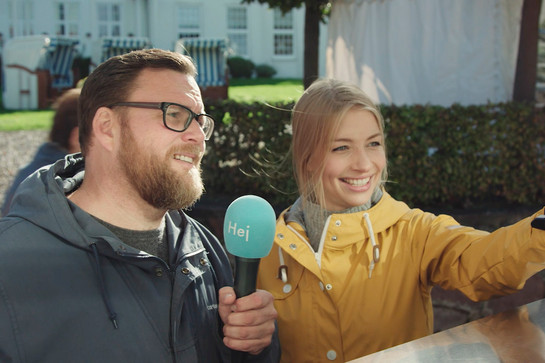 bb_hotdog_teaser_04.jpg Zwei Journalisten stehen an einer Tafel