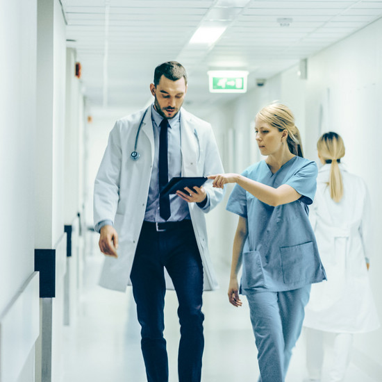 Fingerspitzengefühl Eine Krankenschwester gibt einem Arzt Unterlagen