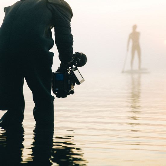 Arbeiten bei uns Quadratisches Bild eines Kameramannes im Wasser, der SUPPER filmt