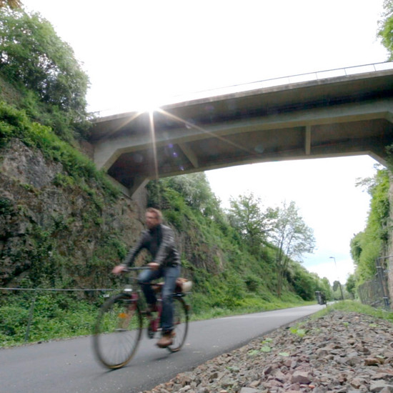 Ein Radfahrer fährt unter eine Brücke