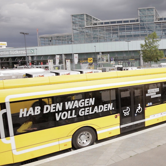 Ein gelber Bus hält vor dem Berliner Flughafen