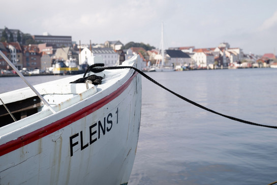 Ein weißes Schiff namens Flens 1 liegt am Flensburger Hafen