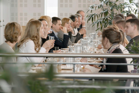 Eine Gesellschaft sitzt an einem langen Tisch und isst