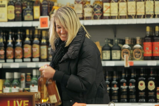 Eine blonde Frau hält zwei Flaschen