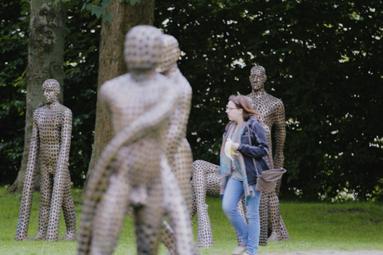 Eine Frau geht durch Skulpturen