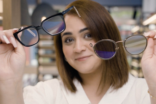 Eine Frau hält zwei Sonnenbrillen in die Kamera