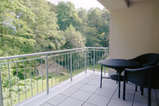 Schwarze Gartenmöbel stehen auf einem Balkon