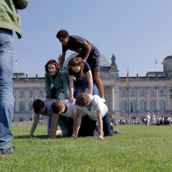 Fünf Jugendliche machen eine Pyramide vor dem deutschen Bundestag