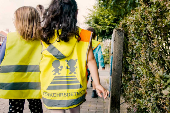 Zwei Kinder tragen gelbe Schutzwesten