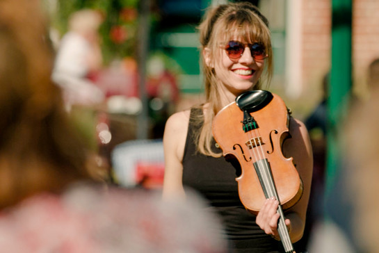 Eine Frau mit Sonnenbrille spielt auf einer Geige