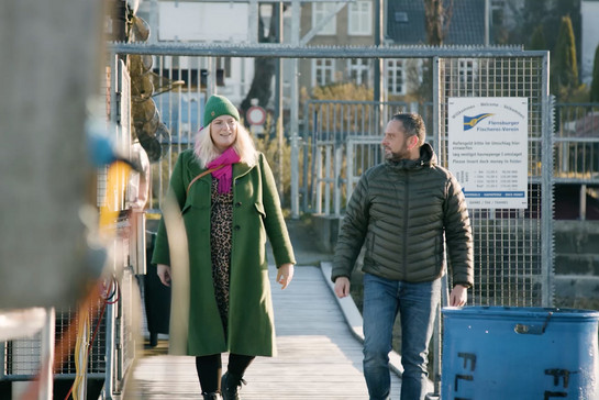Timo Klass geht mit Julia Nissen über einen Steg am Flensburger Hafen