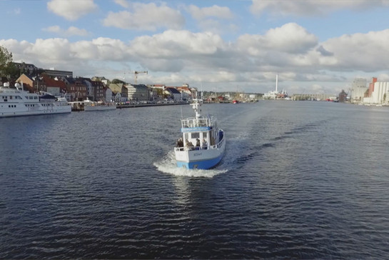 Ein Kutter fährt in den Flensburger Hafen ein