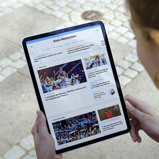 Quadratische Bild einer Frau, die ein Tablet in der Hand hält, das die Website der Kieler Nachrichten zeigt