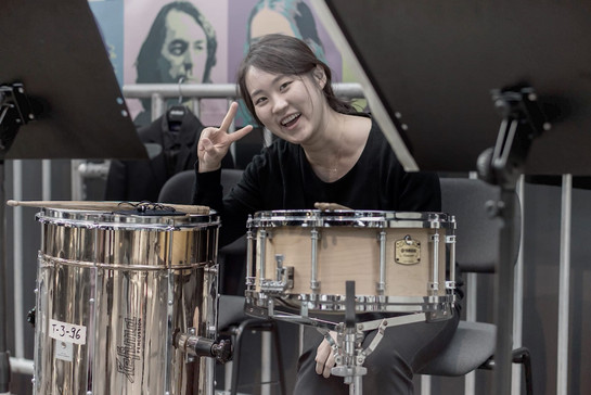 Eine Schlagzeugerin macht ein Peacezeichen mit ihren Händen