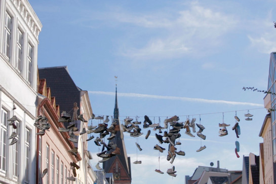 bb_nachbarschaftlichegruesse_teaser_03.jpg Schuhe hängen am Seil in der Norderstrasse
