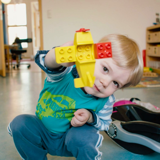Ein Kind zeigt ein lego Spielzeug in die Kamera