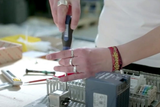 Eine Elektronikerin schraubt an einem Gerät