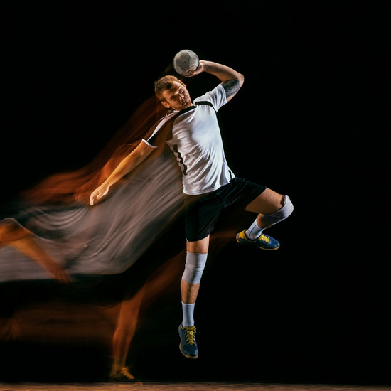 Handballspieler im Sprung vor schwarzem Hintergrund