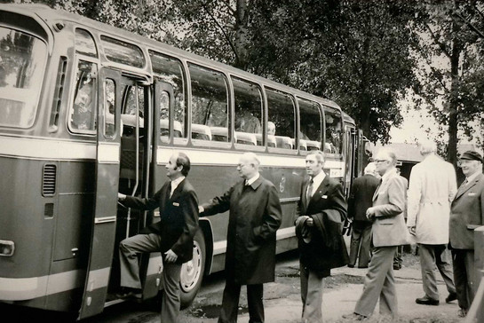 Historische schwarz-weiß Aufnahme von Geschäftsmännern, die in einen Bus einsteigen