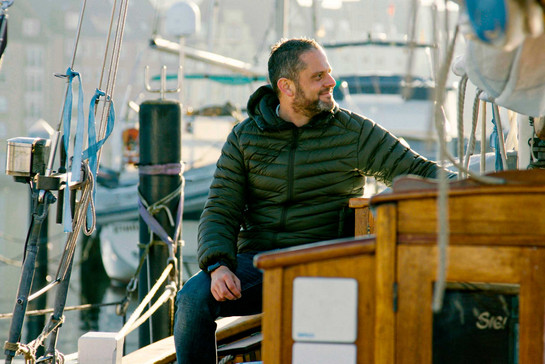 Timo Klass sitzt auf einem Segelboot