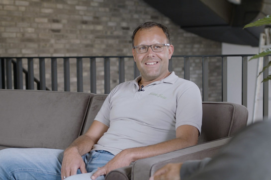 bb_james_teaser03.jpg Mitarbeiter der James Farm sitzt auf einem Sofa