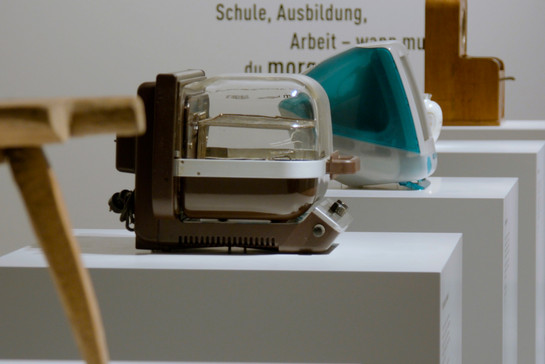 Alte Haushaltsgeräte stehen auf einem Podest in einem Museum
