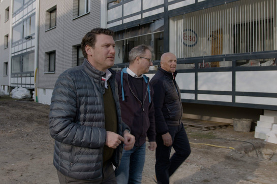 bb_sbv-vorstand_teaser_04.jpg Drei Männer vor einem Wohnhaus