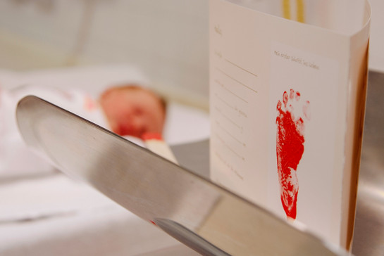 Roter Fußabdruck eines Säuglings auf einem weißen Papier