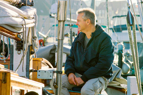Stephan Hansen Oest sitzt lächelnd auf einem Boot