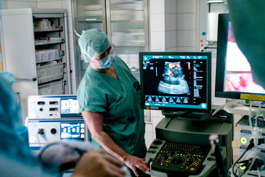 Eine Ärztin steht am Ultraschall Gerät
